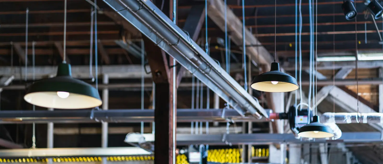 Nave industrial con cañerías y luminarias a la vista