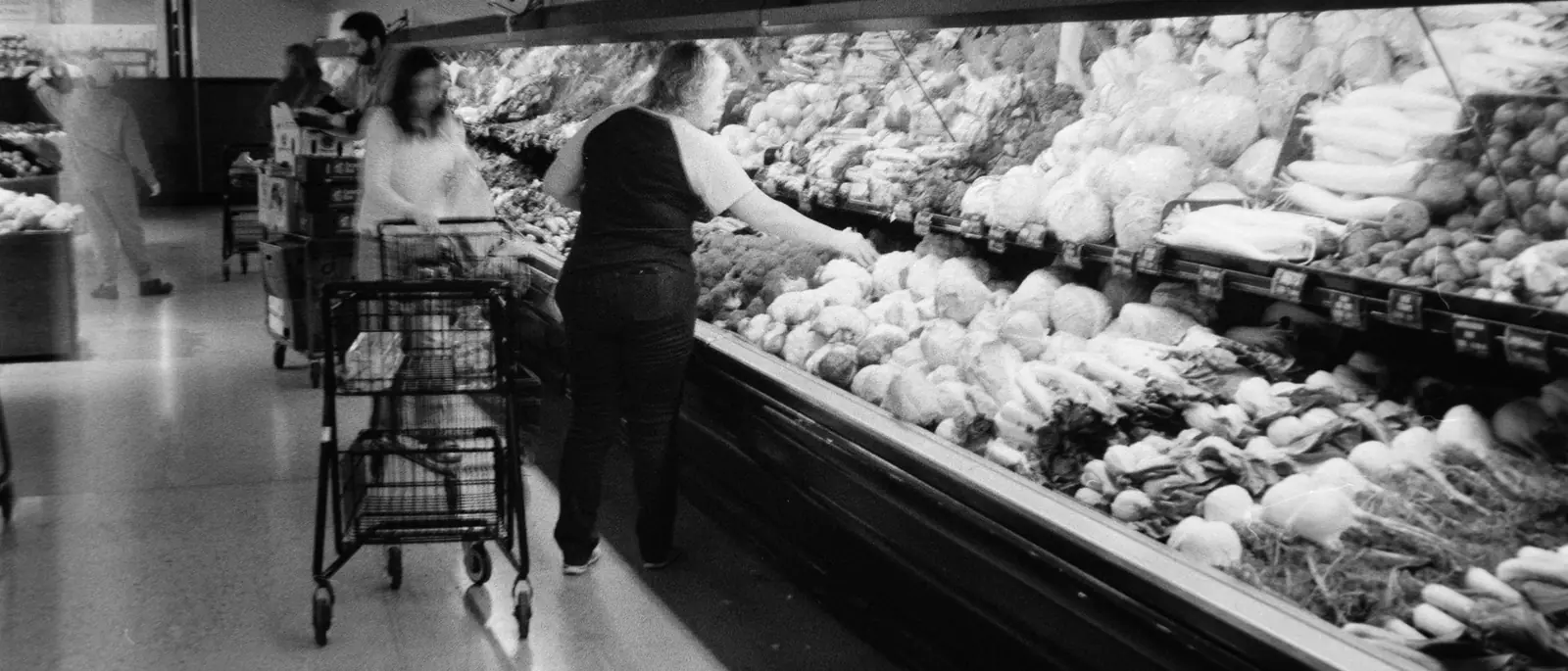 Pasillo de un supermercado con las góndolas de frutas y verduras
